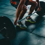 Man performing a deadlift exercise in a gym, demonstrating strength and fitness.